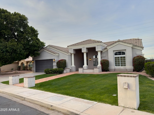 mediterranean / spanish-style house with a garage and a front lawn