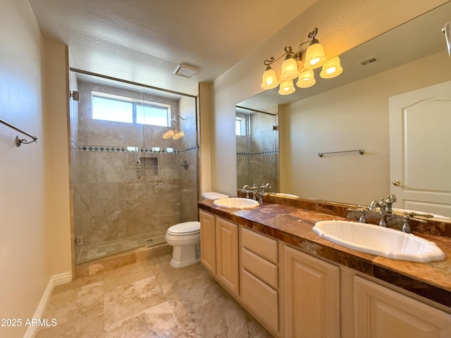 bathroom with a shower with door, vanity, a textured ceiling, and toilet