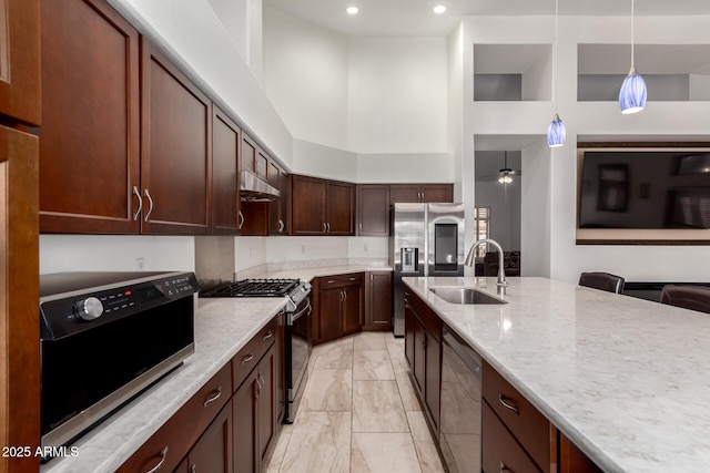 1022 S Butte Ln, Gilbert, AZ 85296 - kitchen with appliances with stainless steel finishes, light marble finish floors, under cabinet range hood, a high ceiling, and light stone countertops