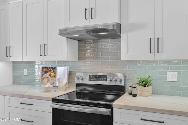 kitchen with stainless steel electric range, white cabinets, exhaust hood, and backsplash