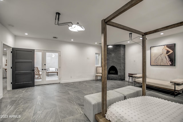 bedroom featuring visible vents, baseboards, access to exterior, french doors, and a high end fireplace