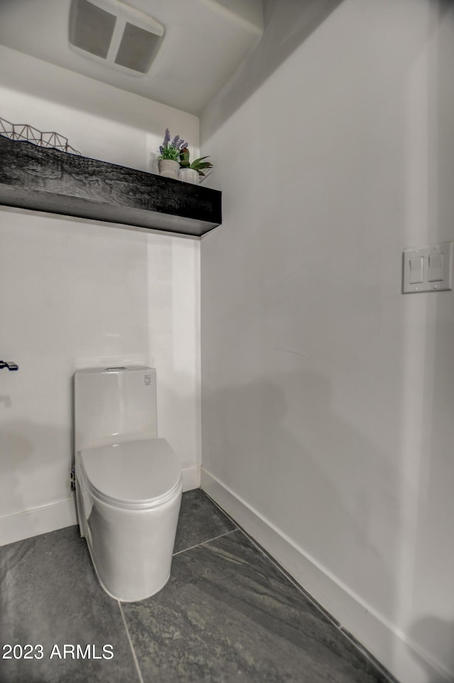 bathroom with visible vents, toilet, and baseboards