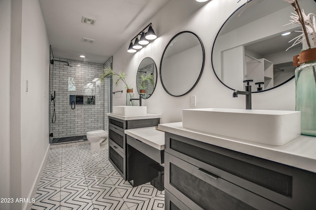 bathroom featuring toilet, a stall shower, vanity, and visible vents