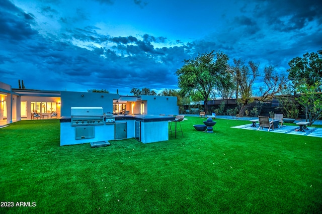 view of yard featuring fence, exterior kitchen, and a patio