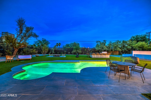 view of pool featuring outdoor dining space, a fenced backyard, a lawn, and a patio