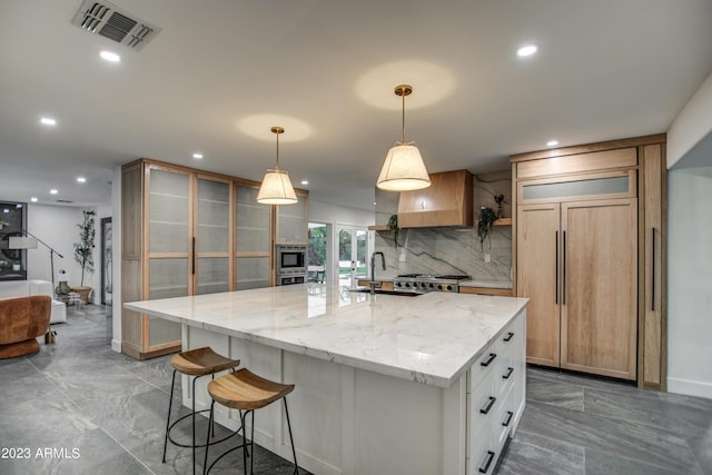 kitchen featuring built in appliances, tasteful backsplash, glass insert cabinets, and visible vents