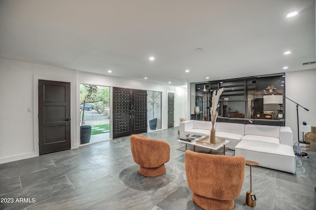 living area with recessed lighting, visible vents, and baseboards