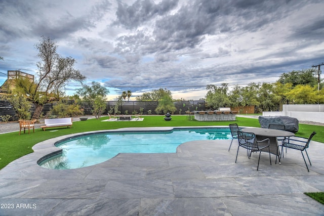 view of pool with a fenced in pool, a lawn, a fenced backyard, a patio area, and outdoor dining space