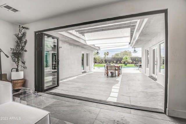 view of patio with french doors, outdoor dining space, fence, and visible vents