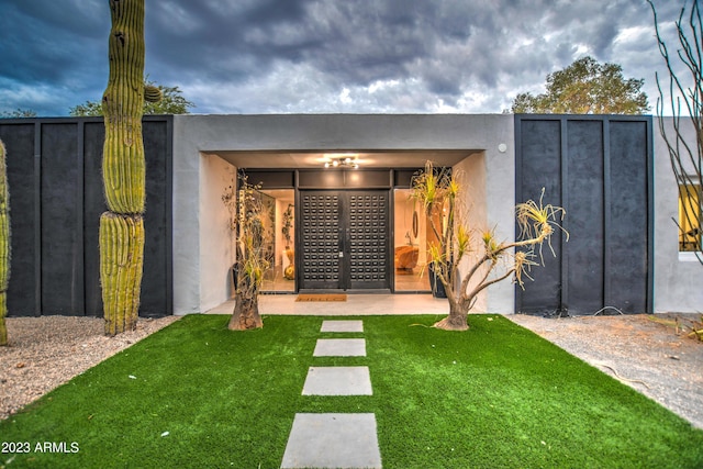 exterior space with a lawn and stucco siding