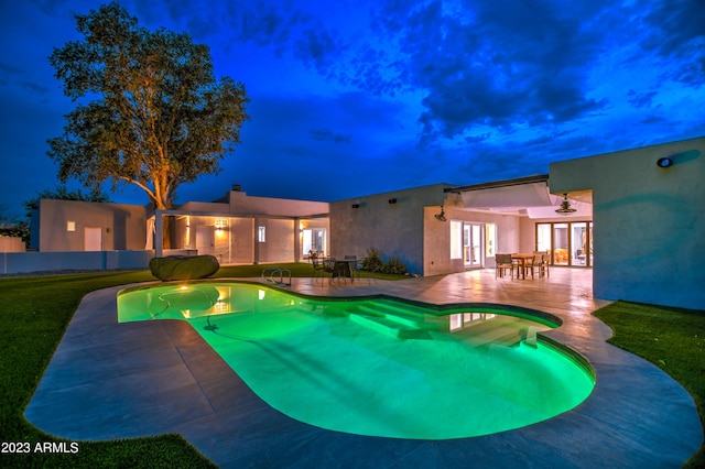 outdoor pool featuring french doors, a patio area, and a yard