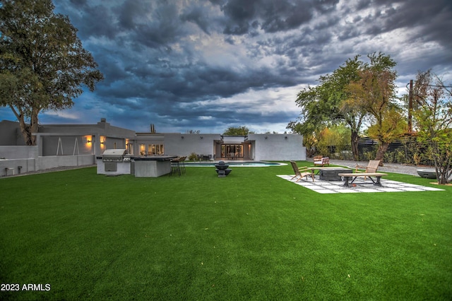 view of yard with a fenced in pool, a patio, a fire pit, and fence