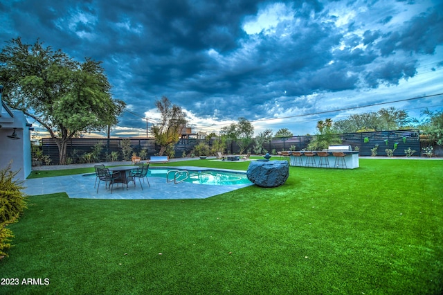 view of swimming pool featuring a fenced in pool, a patio area, a lawn, and a fenced backyard