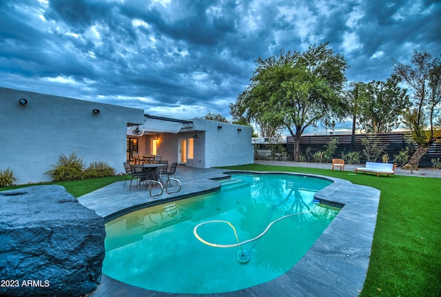 view of pool with a fenced in pool, a patio, a lawn, and fence