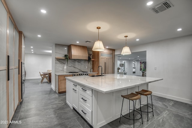 kitchen featuring tasteful backsplash, visible vents, built in appliances, open shelves, and a sink