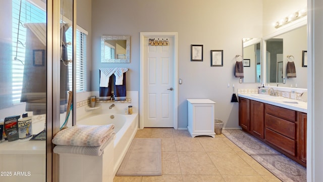 bathroom with tile patterned floors, a tub to relax in, and vanity