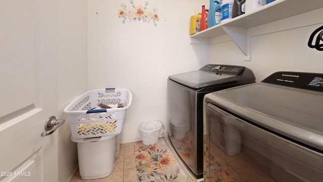 laundry room with washing machine and clothes dryer and light tile patterned floors