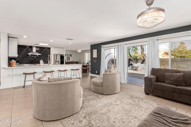 living room with plenty of natural light, light tile patterned flooring, and a notable chandelier