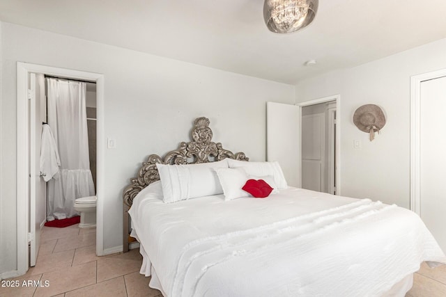 bedroom featuring ensuite bath and light tile patterned flooring