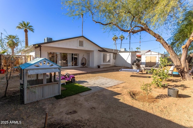 rear view of house with a patio and central AC unit