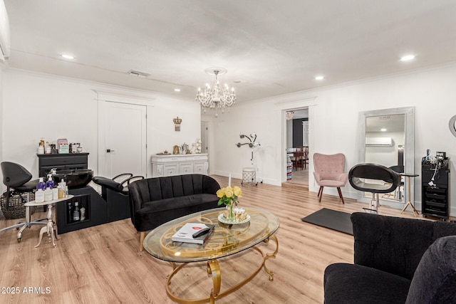 living room with crown molding, light hardwood / wood-style flooring, and a chandelier