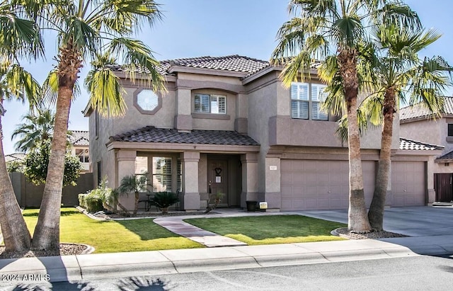 mediterranean / spanish home with a garage and a front lawn