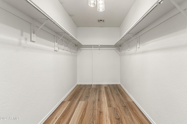 walk in closet with hardwood / wood-style floors