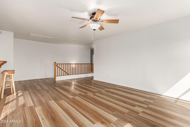 empty room with ceiling fan and hardwood / wood-style floors