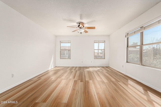 unfurnished room with a textured ceiling, light hardwood / wood-style floors, and ceiling fan