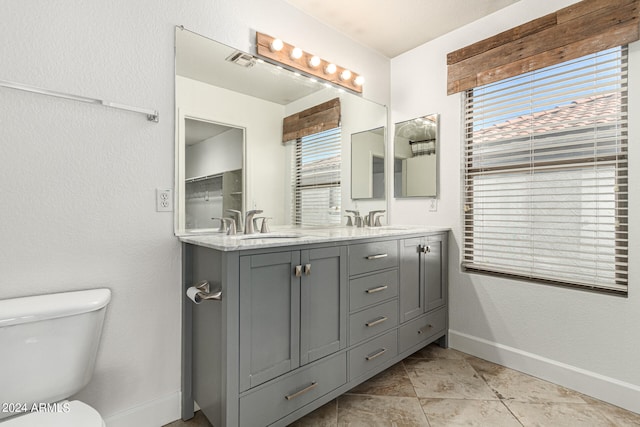 bathroom featuring a wealth of natural light, tile patterned flooring, vanity, and toilet