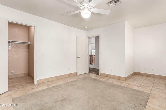 unfurnished bedroom with ceiling fan, light colored carpet, and a closet