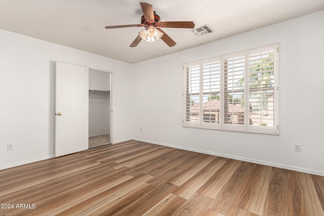 unfurnished bedroom featuring a closet, wood-type flooring, and ceiling fan