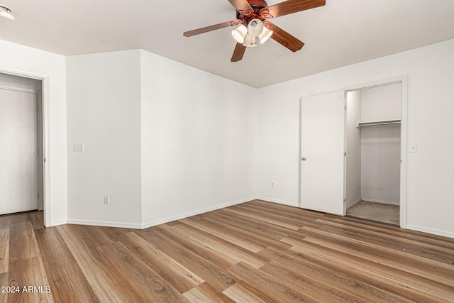 unfurnished bedroom with wood-type flooring, a closet, and ceiling fan