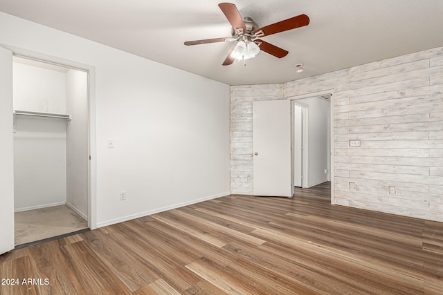 unfurnished bedroom featuring wood-type flooring, ceiling fan, and a closet