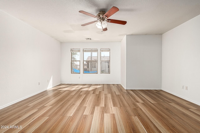 unfurnished room featuring a textured ceiling, light hardwood / wood-style floors, and ceiling fan