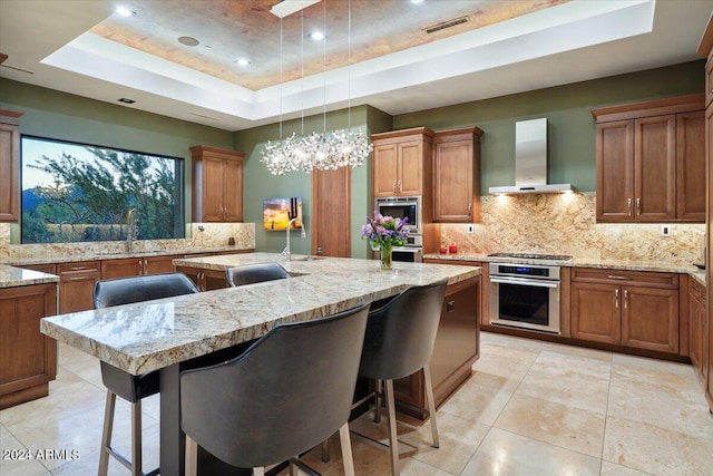 39254 N 104th Pl, Scottsdale, AZ 85262 - kitchen with appliances with stainless steel finishes, wall chimney exhaust hood, brown cabinetry, a raised ceiling, and a sink