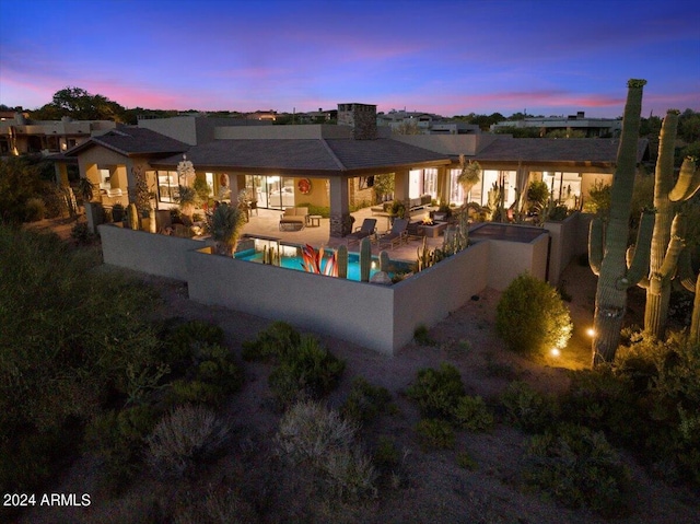 39254 N 104th Pl, Scottsdale, AZ 85262 - back of property at dusk featuring an outdoor pool, a fenced backyard, an outdoor living space, and a patio