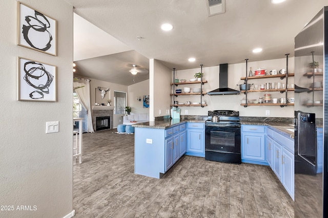 kitchen featuring blue cabinets, black range with electric stovetop, wall chimney range hood, open shelves, and dark countertops