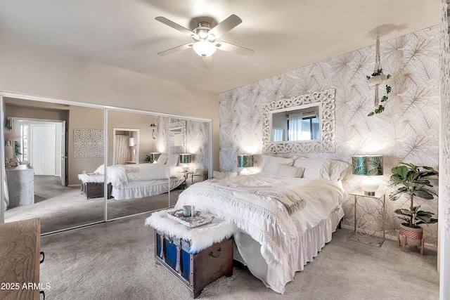 carpeted bedroom with a closet, ceiling fan, and wallpapered walls