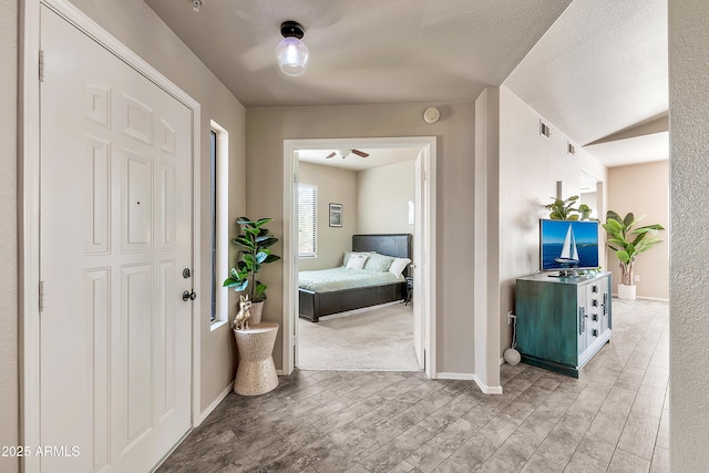 entryway featuring visible vents, a textured ceiling, baseboards, and wood finished floors