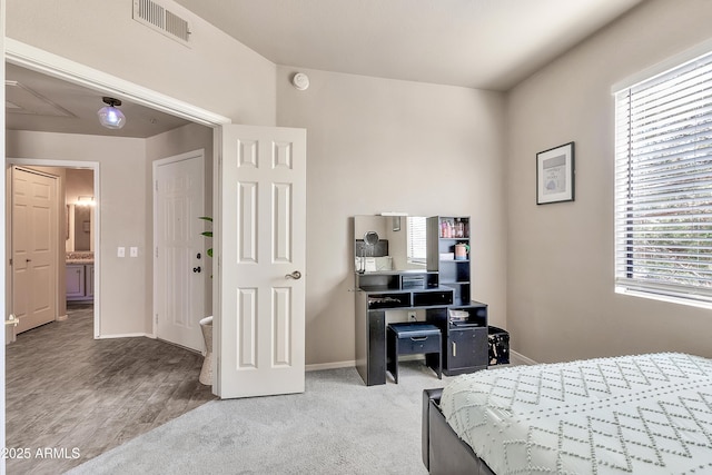 bedroom with visible vents, light carpet, and baseboards