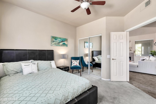 carpeted bedroom featuring baseboards, a closet, visible vents, and a ceiling fan