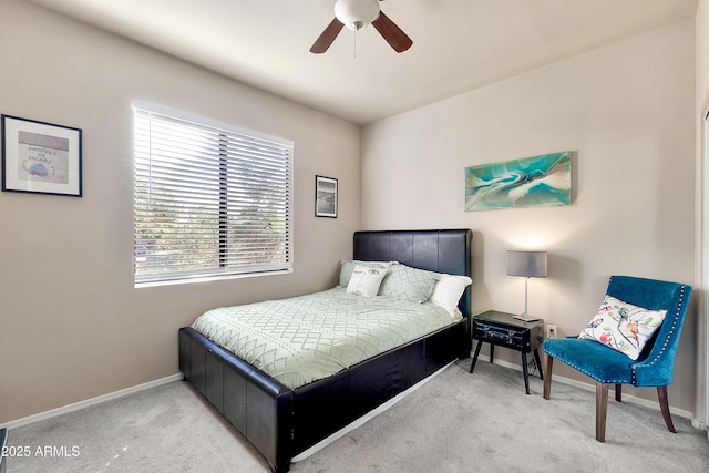 bedroom with a ceiling fan, light carpet, and baseboards