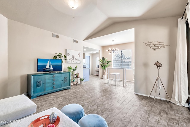 living room featuring vaulted ceiling, wood finished floors, visible vents, and a notable chandelier