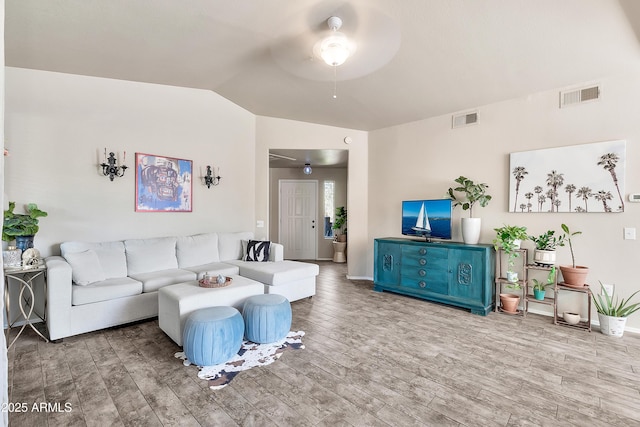 living room featuring lofted ceiling, visible vents, ceiling fan, and wood finished floors