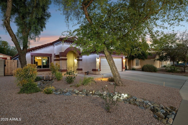 view of front of property featuring concrete driveway, stucco siding, a tiled roof, and a garage