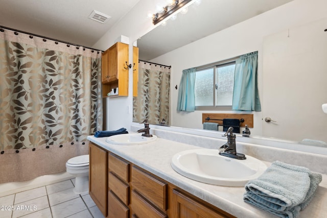 bathroom with a sink, visible vents, toilet, and double vanity