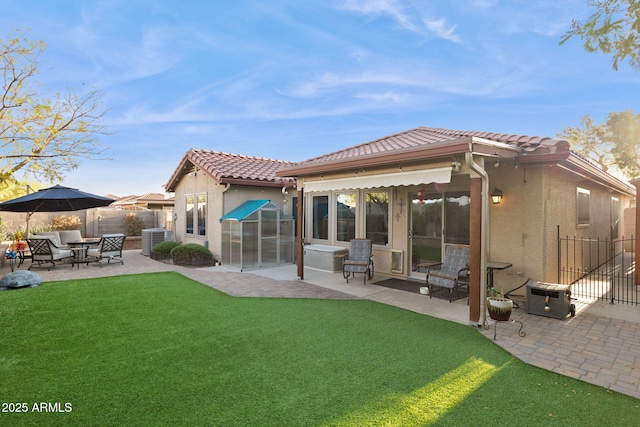 rear view of house with a tiled roof, central AC unit, a patio, and stucco siding