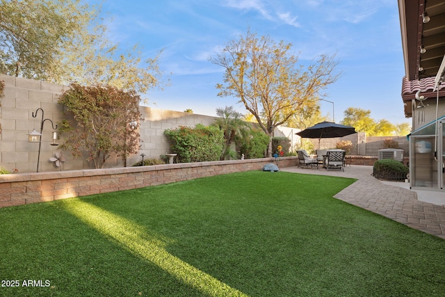 view of yard featuring a patio, central air condition unit, and a fenced backyard