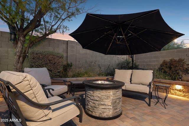 view of patio / terrace with a fenced backyard and an outdoor living space with a fire pit